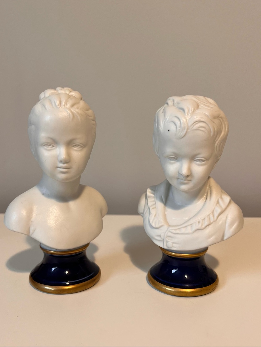 White Porcelain Bust Figurines with Blue and Gold Bases - Pair